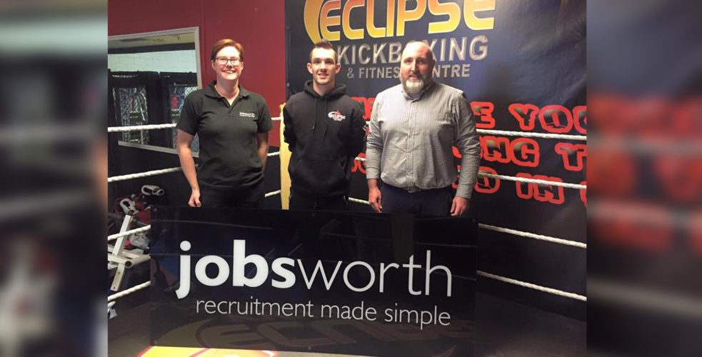 Lucy and Robin with Jobsworth sign stood inside boxing ring with Kyle Williams, local champ
