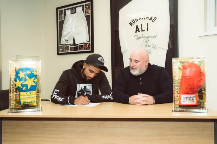 Gully Powar and Rob signing his contract in 2022.